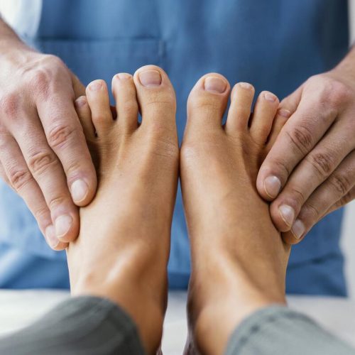 front-view-male-osteopathic-therapist-checking-female-patient-s-toes