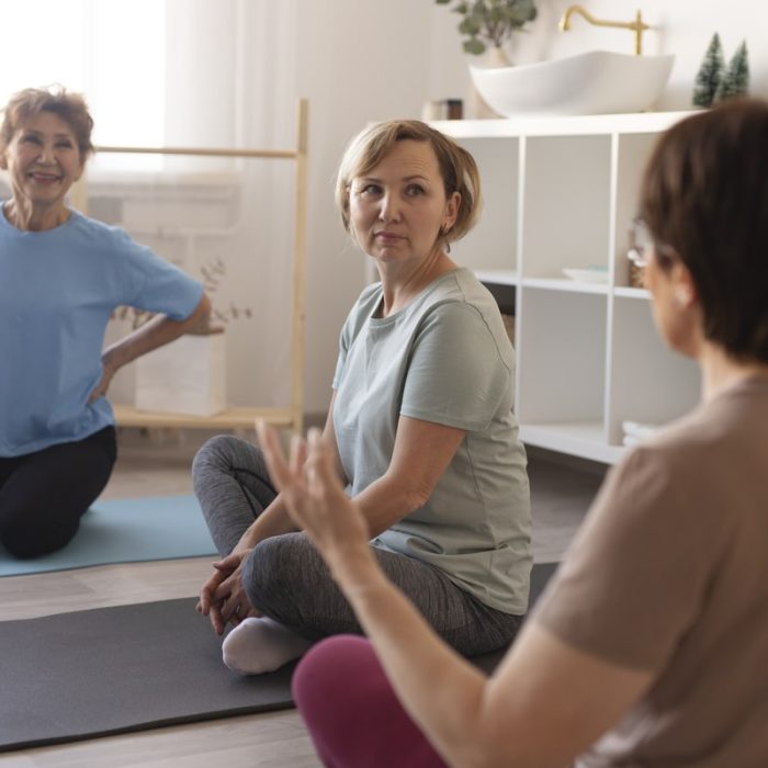 senior-women-doing-exercises-together-home-talking